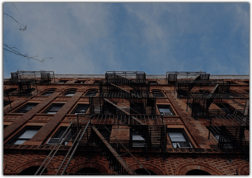 Apartment building with fire escape stairs running along side of it